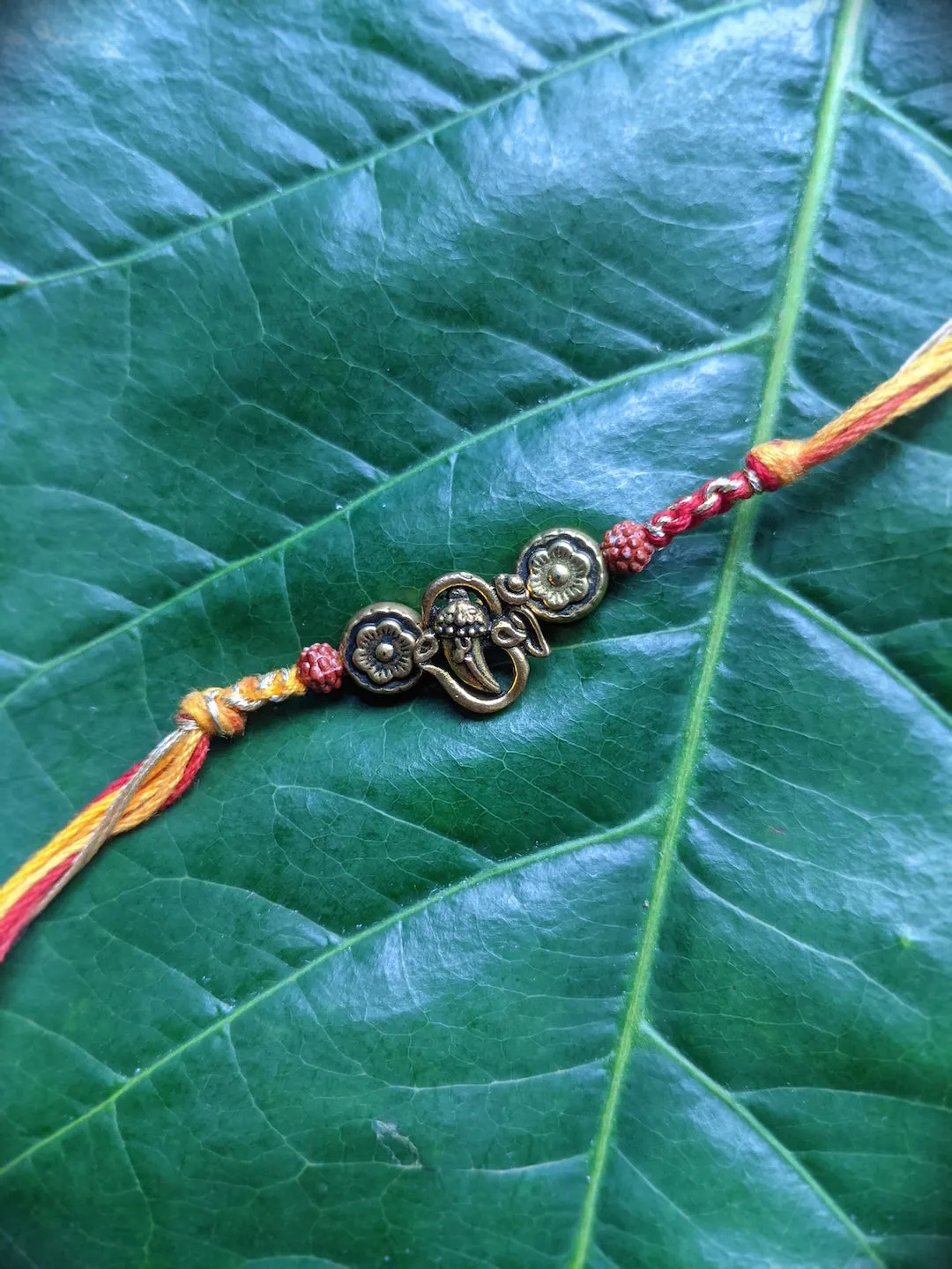Fancy Rakhi Designs Ganesh Ji Pendant with Rudhraksha Multicoloured Mauli Raksha Bandhan