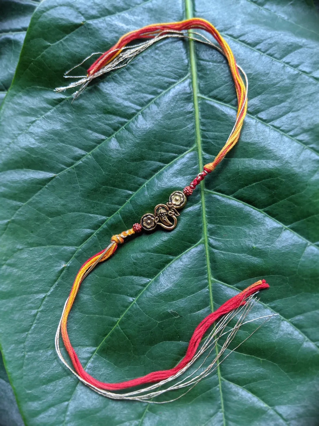 Fancy Rakhi Designs Ganesh Ji Pendant with Rudhraksha Multicoloured Mauli Raksha Bandhan